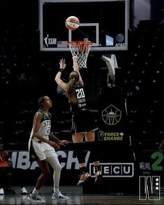 two women are playing basketball on the court