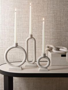 three white candles sitting on top of a table