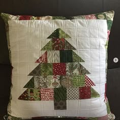 a christmas tree pillow sitting on top of a couch