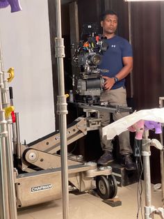 a man standing in front of a camera on top of a tripod next to other equipment