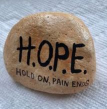 a rock that says hope hold on, pain ends