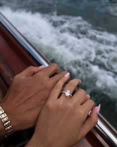 two hands holding each other while on a boat