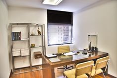 an office with a desk, shelves and chairs