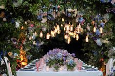 the table is set with flowers and candles for an outdoor dinner party or wedding reception