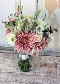 a vase filled with lots of flowers on top of a table