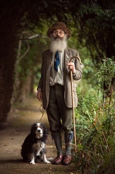 an old man with a long beard is holding a cane and standing next to his dog