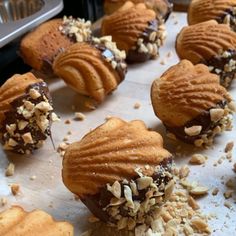 chocolate covered pastries with nuts and almonds on a baking sheet