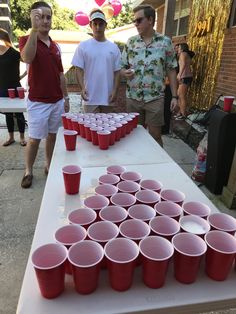 several men standing around a table with cups on it