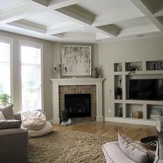 a living room filled with furniture and a flat screen tv mounted on a wall above a fire place