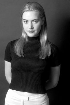 a black and white photo of a woman with long blonde hair wearing a turtle neck sweater