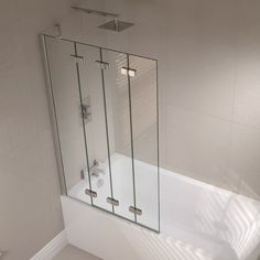 a glass shower door in a white bathroom