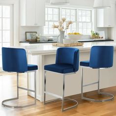 two blue chairs sitting at a kitchen island