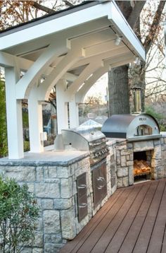 an outdoor bbq and grill area with wood decking