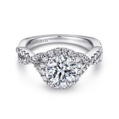 a white gold engagement ring with diamonds on the band and an oval center stone in the middle