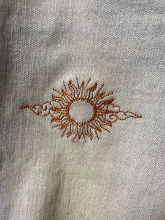 an embroidered sunburst on the back of a pair of jeans