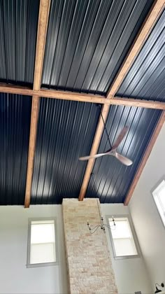 the ceiling in this room is made of metal sheeting and wood planks, with two windows on each side