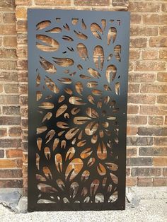 a decorative metal screen on the side of a brick wall