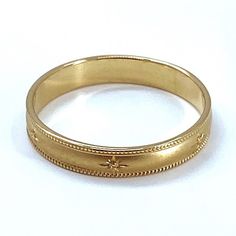 a gold wedding ring on a white background