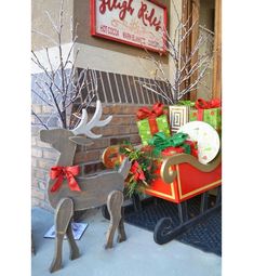 a christmas sleigh with presents on it and a reindeer statue in the foreground