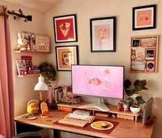 a desk with a computer monitor and keyboard on top of it, surrounded by pictures