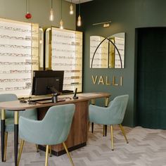 an office with green walls and gold trim around the desk, along with two blue chairs