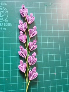 a purple flower on a green cutting board