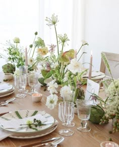 the table is set with flowers and candles