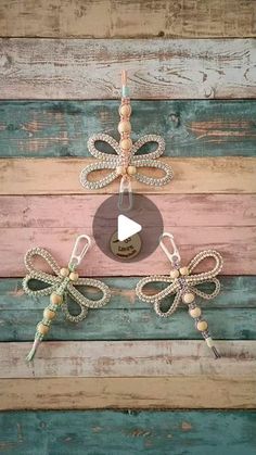 three dragon ornaments hanging on the side of a wooden wall with string attached to them