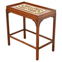 a wooden table with an intricate design on the top and bottom, sitting against a white background