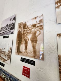 some pictures are hanging on the wall with people in bathing suits and one is holding a child