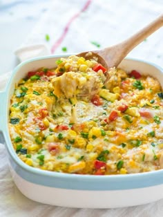 a casserole dish with vegetables and cheese being scooped from the casserole