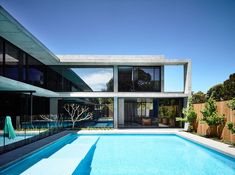 an empty swimming pool in front of a modern house