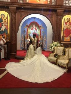 a bride and groom sitting in front of the alter