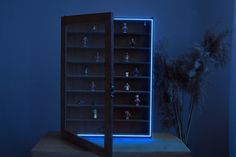 an illuminated display case filled with toy figurines on top of a wooden table