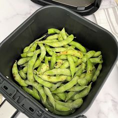 green beans are in a black container on the counter