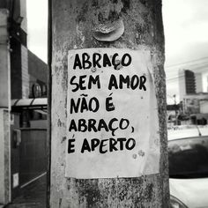 a sign posted on a pole in front of a building that says, abraco sem amor nao e abaco e aperito