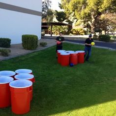 two men are playing with red cups in the yard