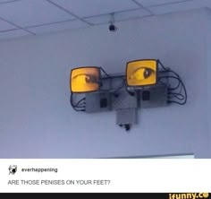 there are two yellow lights on the wall and one has eyes drawn on it's side