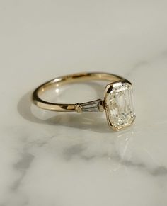 an engagement ring with a large diamond in the center on a marble countertop top