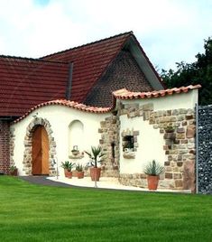 a white house with red tile roofing and green grass