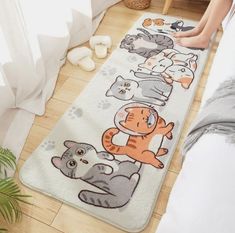 a person laying on the floor next to a rug with cartoon cats and kittens