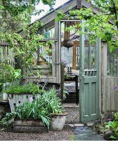 a garden shed with potted plants in it