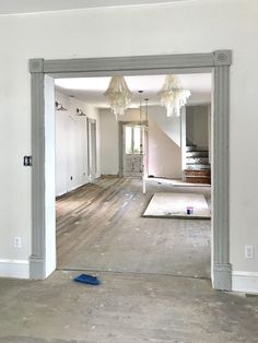 an empty living room with white walls and wood floors is being painted in the process of remodeling