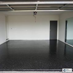 an empty room with black floors and white walls