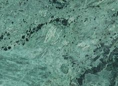 a green marble counter top with black dots on it