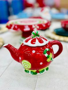 red teapots with green and white designs on them are sitting on a table