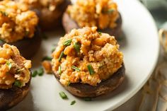 stuffed mushrooms topped with stuffing on a white plate