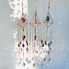 a group of different colored crystals hanging from strings