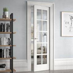 an empty room with bookshelves and a white door