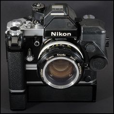 an old style camera with a lens attached to it's body and the words nikon on the front